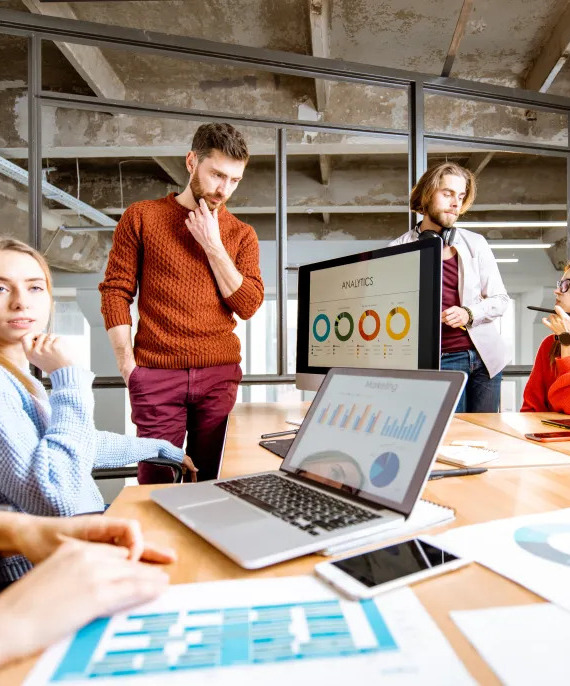 A group of mixed people stood around discussing marketing projects